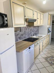 a kitchen with white appliances and a white refrigerator at Maison authentique du Vexin in Théméricourt