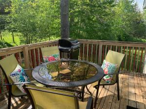 a table and chairs on a deck with a grill at 3 bedrooms home in Kentville