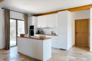a kitchen with white cabinets and a large island at Maisons H Normandie in Cricquebœuf