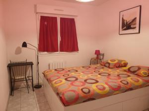a bedroom with a bed and a red window at Petite maison du samedi au samedi in Biscarrosse