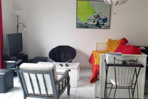a living room with a table and chairs and a bed at Petite maison du samedi au samedi in Biscarrosse +4 photos