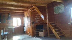 a room with a staircase in a log cabin at Domki Orla na Mazurach in Pasym