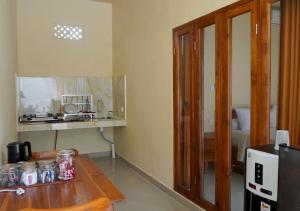 een keuken met een houten tafel en een aanrechtblad bij Made 02 Balangan, Homestay, Villas, & Warung Made02 in Uluwatu