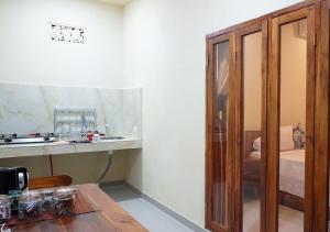 een kamer met een tafel en een houten kast bij Made 02 Balangan, Homestay, Villas, & Warung Made02 in Uluwatu +36 foto's