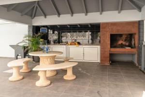 una cucina con tavolo, 2 panche e bancone di Villa Salinas a Paul do Mar