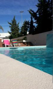 - une piscine d'eau bleue et 2 chaises dans l'établissement Vacances Tranquilles, à Olhos de Água