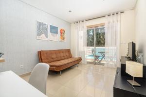 un salon avec un canapé et une télévision dans l'établissement Vacances Tranquilles, à Olhos de Água