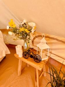 a table with a vase of flowers and a bike on it at Quex Glamping in Birchington