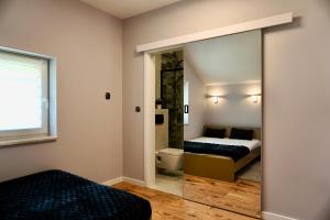 a bedroom with a bed and a bathroom with a mirror at Pod Dębową Koroną in Kazimierz Dolny