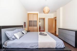 une chambre avec un grand lit avec des draps blancs dans l'établissement Vacances Tranquilles, à Olhos de Água 26 autres photos