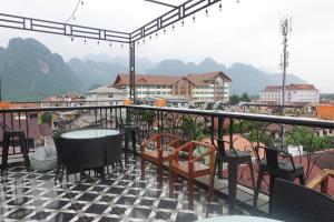 a balcony with a table and chairs and a view of mountains at Champa Riverside Hotel in Vang Vieng