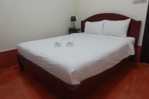 a large bed with two white pillows on it at Champa Riverside Hotel in Vang Vieng