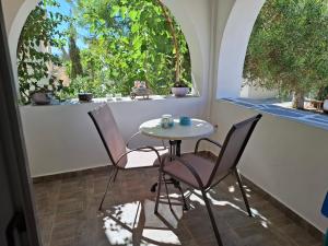 a table and chairs in a room with two windows at Actis studios 2 in Stelida