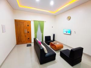 a living room with two chairs and a couch at Griya Anindita in Sumberrejo
