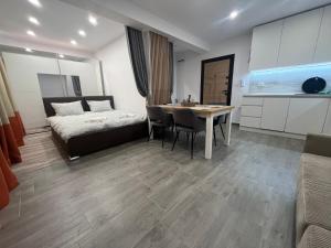 a bedroom with a bed and a table in a room at Sarafovo Relax Night in Burgas City