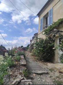 a stone path next to a house at Parenthèse entre forêt et château in Pierrefonds