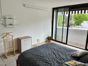 a bedroom with a bed and a large window at Le Gryselis in Gréoux-les-Bains