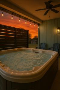 a jacuzzi tub in a room with a sunset at Modern Pigeon Forge Gem Near Dollywood, Gatlinburg & Smokies - 2 Mins to Pkwy & Strip, Hot Tub, Fire Pit, Cable, Hi-Speed WiFi in Pigeon Forge