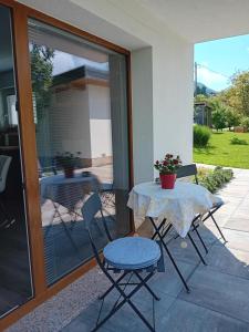 a table and chairs sitting on a patio with a glass door at Apartma - Hiša Zofija in Slovenske Konjice