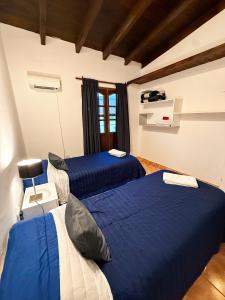two beds in a room with blue sheets at KAKAN - Dpto 2 dormit- Primer piso in Cafayate