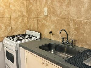 a kitchen with a sink and a stove at KAKAN - Dpto 2 dormit- Primer piso in Cafayate