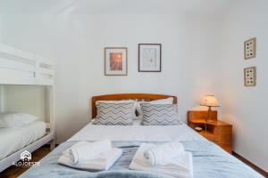 un dormitorio con una cama con dos almohadas en Azenha Beach House - Sea view with BBQ, en Santa Cruz