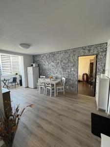 a living room with a table and chairs and a kitchen at The Home in Gheorgheni