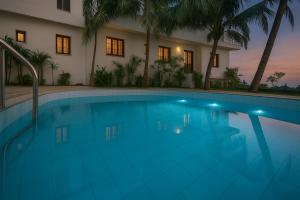 卡兰古特Casa Da Village Calangute Goa的夜晚房子前的游泳池