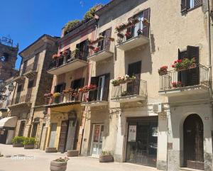 a building with flower boxes and balconies on a street at Casa Makarina - Camere centro storico in Mazzarino