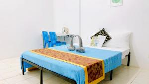 长滩岛Glo's Space Boracay Dmall By TripzyFun的配有一张床和两张蓝色椅子的房间