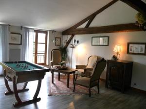un soggiorno con tavolo da biliardo e sedie di La Maison de Marie - Chambres d'Hôtes au Lac du Der a Droyes