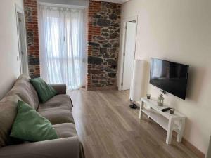 Una sala de estar con un sofá y un televisor de pantalla plana. en Precioso piso 1 muy cerca de la playa de Salinas, en Piedras Blancas