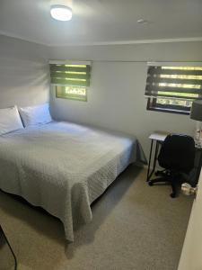 a bedroom with a bed and a desk and a chair at A space of your own in Rotorua
