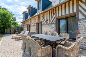 a table and chairs sitting outside of a building at Maisons H Normandie in Cricquebœuf