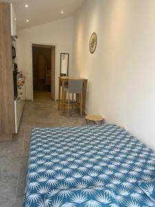 a bedroom with a blue and white bed and a table at Studio L'Essentiel in Istres