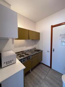 een keuken met een spoelbak en een fornuis bovenste oven bij Euro Residence in Lignano Sabbiadoro