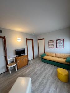 een woonkamer met een bank en een tv bij Euro Residence in Lignano Sabbiadoro