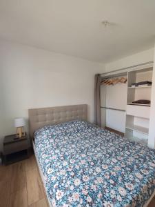 a bedroom with a bed with a floral bedspread at Evasion Réunionnaise in Maison Henou