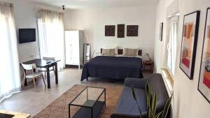 a bedroom with a bed and a living room with a table at 2-Person Studio, Private Splash Pool, 5 Min Beach in Novo Sancti Petri