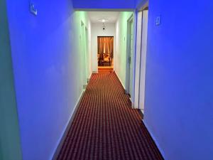 a long hallway with blue walls and a red floor at Panakal Residency, Fort Kochi in Cochin