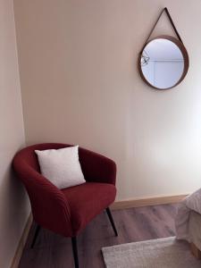 a red chair in a room with a mirror at Le Terracotta - Parking privé in Langres