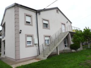 a white house with a staircase on the side of it at Boskovic Apartments in Podgorica
