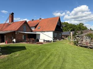 a barn with a grass yard in front of it at Ferienwohnung am Eschenberg in Vinstedt