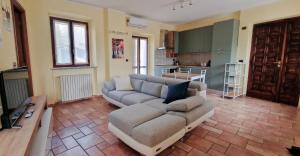 a living room with a couch and a kitchen at Monferrato Street House in Calliano