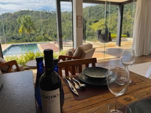 塞拉内格拉Exclusive Cabanas的桌子上有一瓶酒和两个酒杯