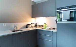 a kitchen with white counters and blue cabinets at Locarno Center - Free Parking, Netflix and WiFi in Locarno +65 photos