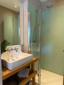 a bathroom with a sink and a glass shower at Maison familiale et cosy à la mer in Saint-Valery-sur-Somme