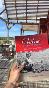 a person holding a book in their hand at Casa Chiloe in Penanes Bajo