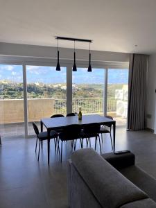 沙拉The Valley Collection - Suite A21的带桌椅和大窗户的客厅