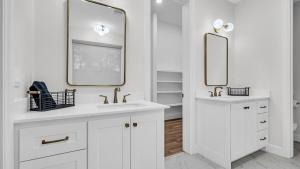 a white bathroom with two sinks and two mirrors at Texoma Elegance in Kingston +25 photos